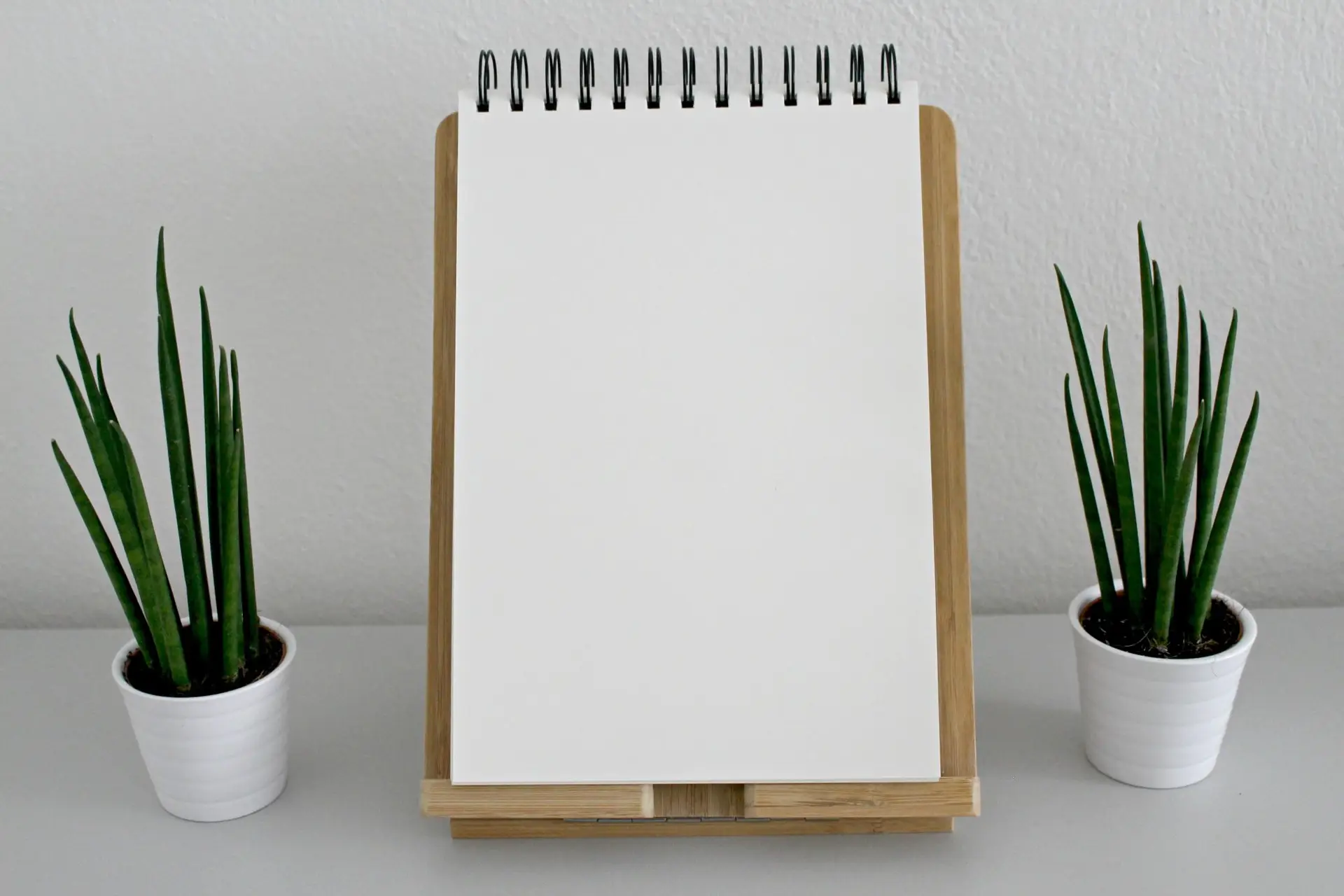 Notebook and plants on a desk with a message about tax return meetings at Business Edge Advisors